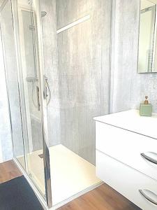 Un baño blanco con ducha y lavabo. en Orvilliers, en Moulins