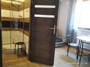 drewniane drzwi w pokoju z prysznicem w obiekcie Hotelik rodzinny 365 pokoje z łazienkami w Łodzi