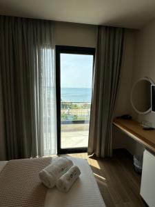 a bedroom with a window with a view of the ocean at Hotel Utopia in Ksamil