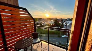 a balcony with a table and chairs and the sunset at Baltic Sunsets in Międzyzdroje