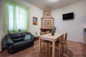 ein Wohnzimmer mit einem Sofa und einem Tisch in der Unterkunft Casale dello zio, private wood in Castellana Grotte