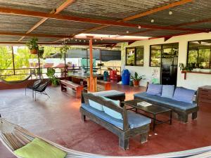 a patio with a hammock and tables and chairs at Villas Jacquelina in Quepos