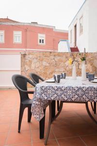 a table with chairs and a tablecloth on a table at Casa do Sol Nascente in Foz do Arelho