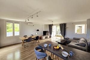 a living room with a couch and a table at Le Belvédère + Clim + Extérieur + Parking Gratuit in Les Angles Gard