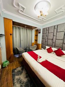 een slaapkamer met een groot bed met rode kussens bij Hotel Avalanche in Shimla