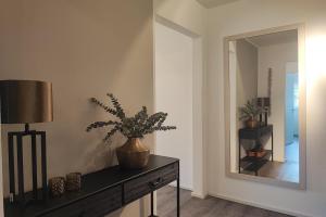 エッカーンフェルデにあるHafenspitzeの鏡と植物のテーブルが備わる部屋