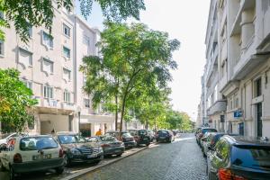 Une rangée de voitures garées dans une rue à côté des bâtiments dans l'établissement Apartament with a terrace in the heart of Lisbon, 300, à Lisbonne