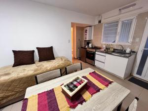 a room with a bed and a kitchen with a table at Bahía Golondrina in Ushuaia