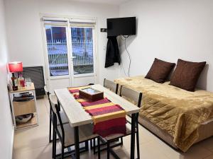 Habitación con cama y mesa con sillas. en Bahía Golondrina en Ushuaia
