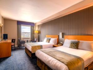 una camera d'albergo con due letti e una finestra di City Hotel a Londonderry