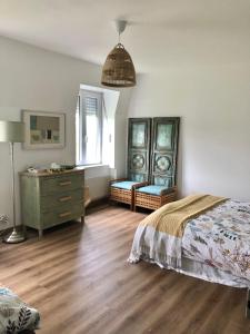 sypialnia z łóżkiem i komodą w obiekcie La Maison du Hommeel w mieście Gratot