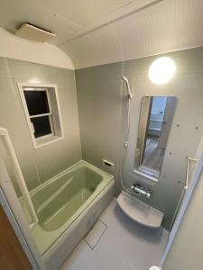 La salle de bains est pourvue d'une baignoire verte et de toilettes. dans l'établissement Guest house HaDuNo - Vacation STAY 85297v, à Shingu