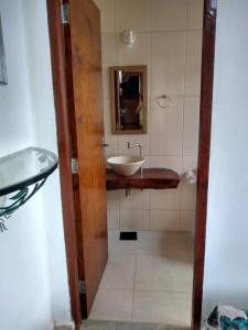a bathroom with a sink and a mirror at Chalés Excalibur in São Thomé das Letras
