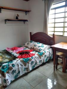 a bed sitting in a room with a table at Chalés Excalibur in São Thomé das Letras