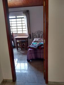 a bedroom with a bed and a table in a room at Chalés Excalibur in São Thomé das Letras