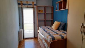 a small bedroom with a bed with a blue wall at Soria Naturaleza in Soria