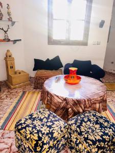 een woonkamer met een tafel en 2 stoelen bij Villa Naoual in Moulay Bousselham