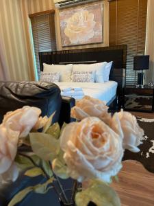 ein Schlafzimmer mit einem Bett und einer Vase mit Rosen in der Unterkunft Romlaphass Boutique hotel in Kalasin