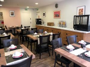 a restaurant with wooden tables and chairs and a counter at Hôtel Le Commerce in Modane