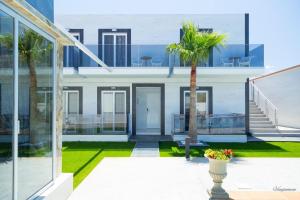 a house with a palm tree in a courtyard at Paradice Hotel Luxury Suites-Near zorbas Beach-FREE Breakfast in Stavros