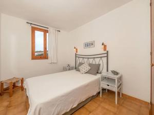 une chambre avec un grand lit blanc et une table dans l'établissement Xaloc , apartamento con piscina y junto la playa, à Arenal d'en Castell