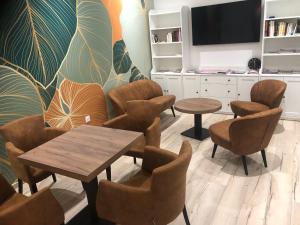 una sala de espera con sillas, mesa y TV en Hôtel Le Commerce, en Modane