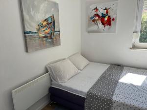małą sypialnię z łóżkiem i 2 zdjęciami na ścianie w obiekcie Apartments Mia w Bibinje