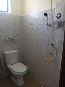 a bathroom with a toilet and a shower at HOMESTAY DESA TERATAI in Kampong Ulu Chuchoh +5 photos