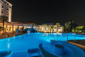 a large swimming pool in a hotel at night at Hotel Terme Helvetia in Abano Terme