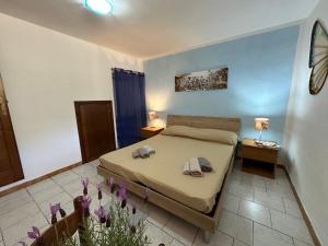 ein Schlafzimmer mit einem Bett mit zwei Handtüchern darauf in der Unterkunft Appartamenti magnolie-La pineta in Valledoria
