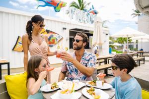 a family eating food at a table at a restaurant at Nickelodeon Hotels & Resorts Punta Cana - Gourmet All Inclusive by Karisma in Punta Cana
