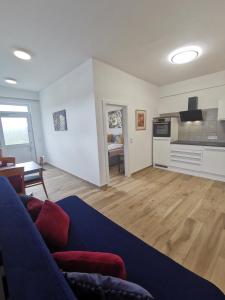 a living room with a blue couch and a kitchen at One1-Apartments in Kötschach +36 photos
