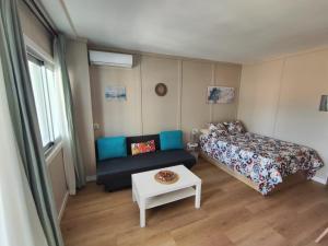 een slaapkamer met een bed, een bank en een tafel bij Céntrico estudio en Torremolinos in Torremolinos
