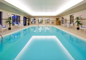 a large swimming pool with blue water in a building at Holiday Inn Express Hotel & Suites Detroit-Utica by IHG in Utica