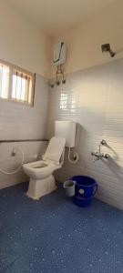 a bathroom with a toilet and a bucket in it at The Heritage Serviced Apartments in Mandya