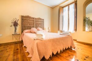 1 dormitorio con 1 cama con toallas en Ronda del Castillo en Olite