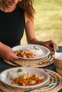 una mujer sentada en una mesa con dos platos de comida en Ibera Lodge en Mercedes