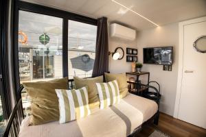 um quarto com uma cama com almofadas e uma janela em The Homeboat Company Sant'Elmo-Cagliari em Cagliari