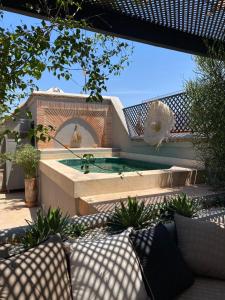 a backyard with a swimming pool and a house at RIAD DAR C in Marrakech
