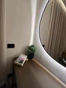 ein Spiegel an einer Wand neben einem Tisch mit einem Buch in der Unterkunft Holiday House in Neapel