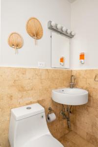 een badkamer met een wit toilet en een wastafel bij 2-BR Apt centrally located in OSJ! in San Juan