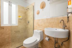 a bathroom with a white toilet and a sink at 2-BR Apt centrally located in OSJ! in San Juan