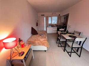 1 dormitorio con cama, mesa y cocina en Bahía Golondrina 2 en Ushuaia