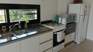 a kitchen with a stove and a sink and a refrigerator at Moderna y Confortable casa nueva in Santiago del Estero