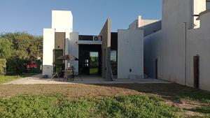 a white building with a table and an umbrella at Moderna y Confortable casa nueva in Santiago del Estero