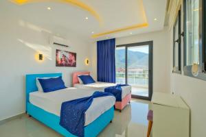 two beds in a room with a window at Alternatif Villaları in Fethiye