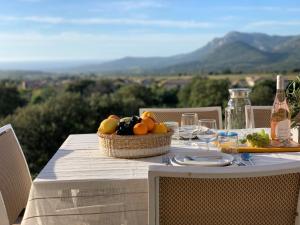 a table with a basket of fruit on top at Résidence 3 étoiles Pietra Gemina - Appartements de vacances, au calme, avec Piscine in Calenzana