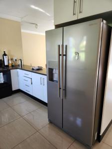 eine Küche mit einem großen Kühlschrank aus Edelstahl in der Unterkunft Dollar Zone in Manzini