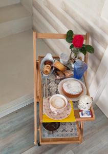 une petite table avec de la nourriture et un vase avec une rose dans l'établissement La Casa della Rosa Nana, à Trezzano sul Naviglio