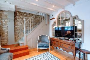 a living room with a tv and a chair and a desk at Cosy Little Hyde Cottage, Swanage in Swanage
